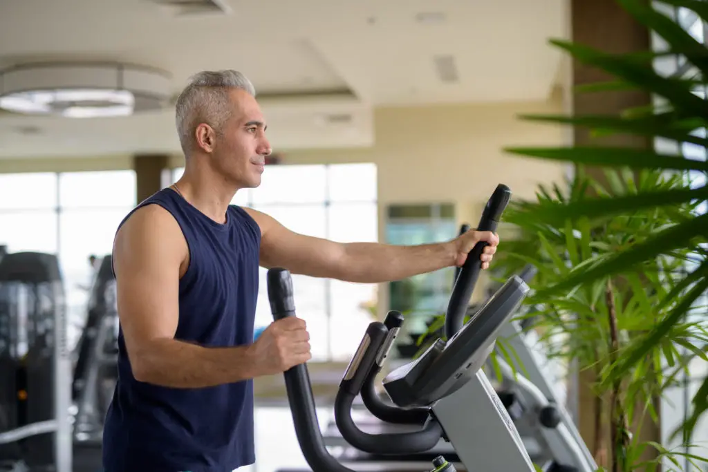 Man Exercising with Elliptical Trainer Machine