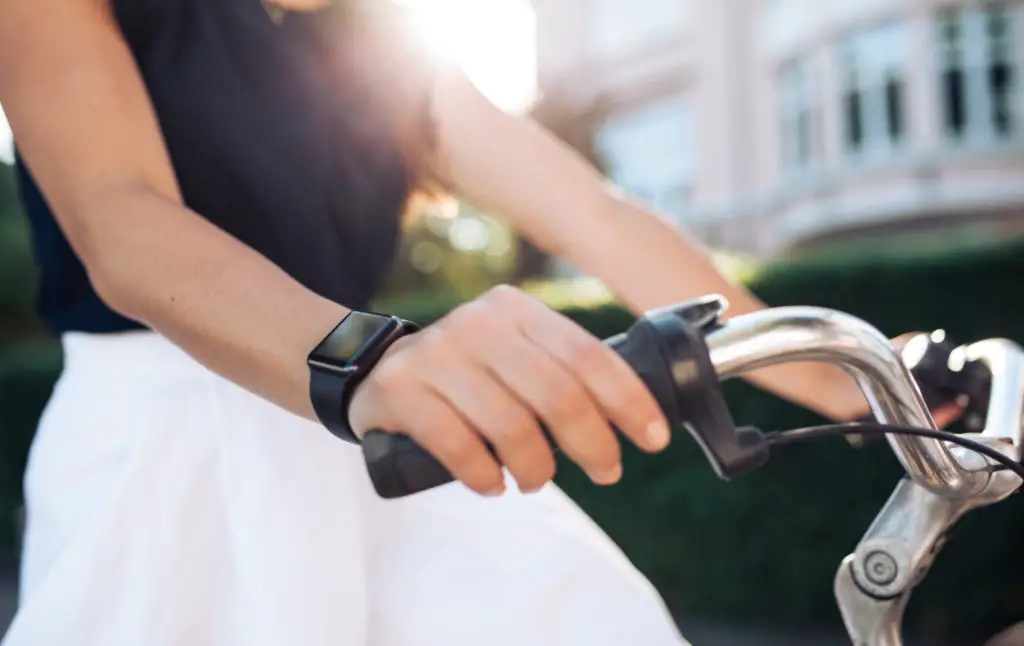 Woman Riding a Bike With a Fitness Tracker