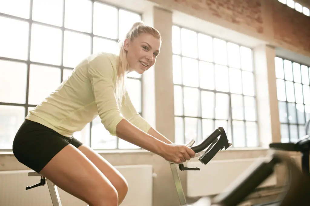  Frau reitet auf Heimtrainer