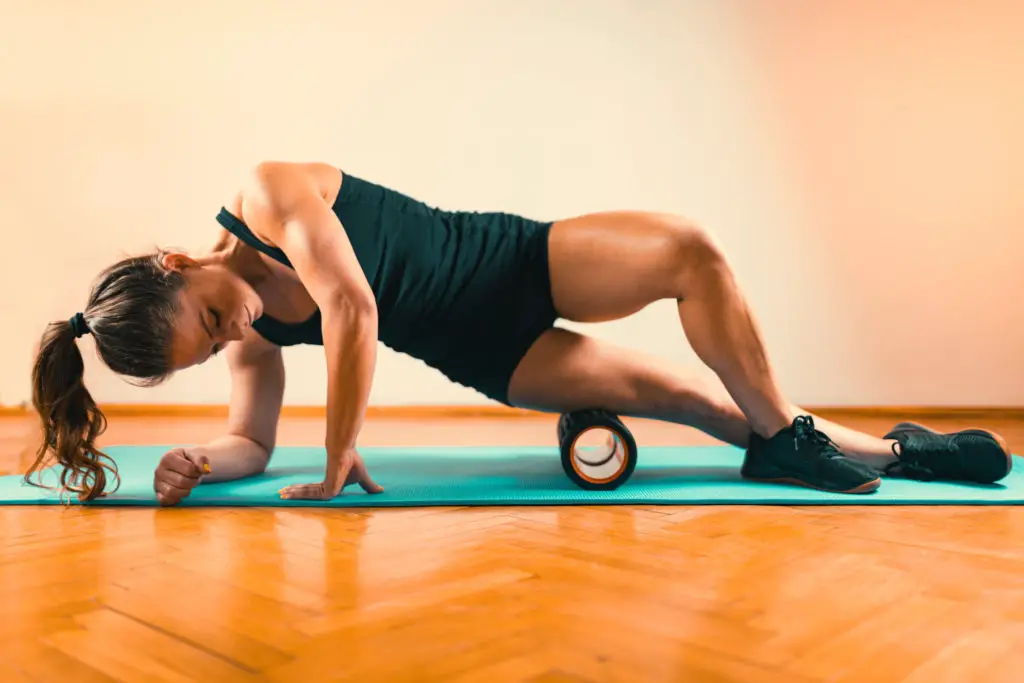 Woman Massaging Legs with Foam Roller