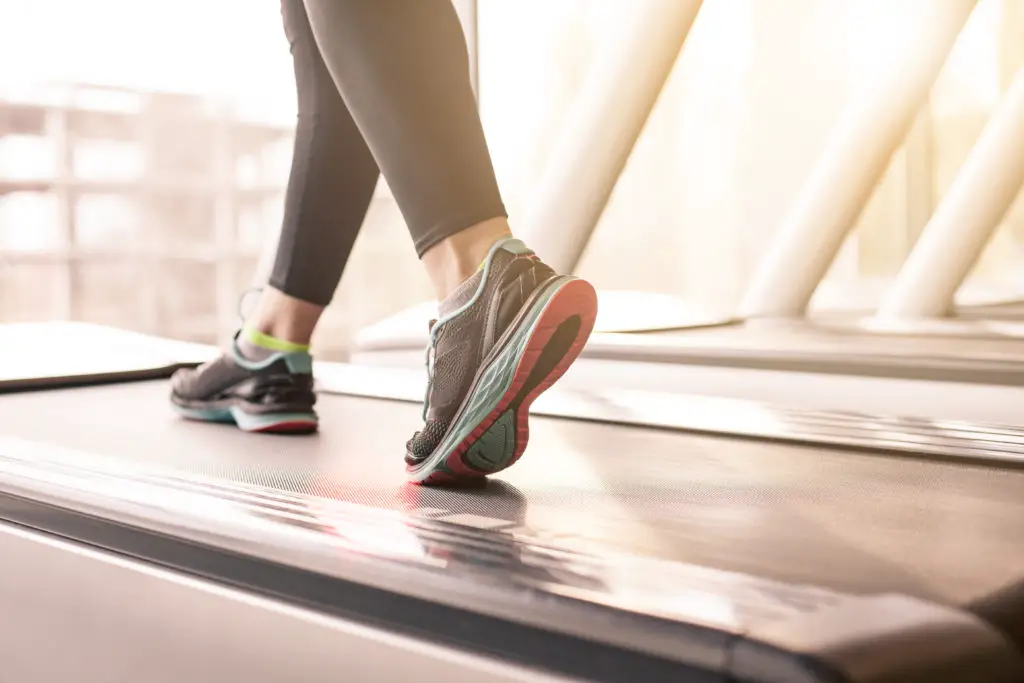 Woman Running On Treadmill in Gym